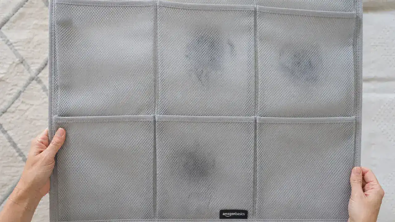 Overhead view of six mesh pockets showing white scuff marks from dark rubber soles on the light grey mesh fabric after several months of use
